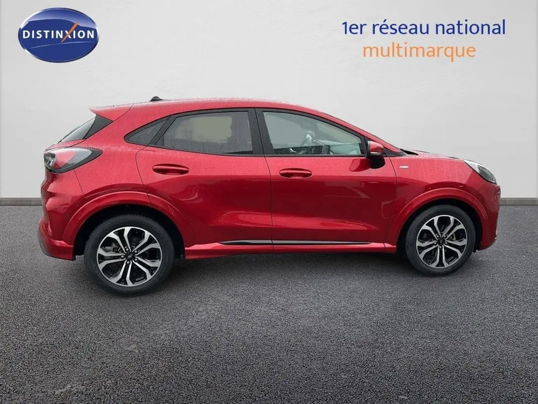 Vue latérale côté gauche d'un Ford Puma rouge 2020 avec jantes alliage et lignes sportives marquées.