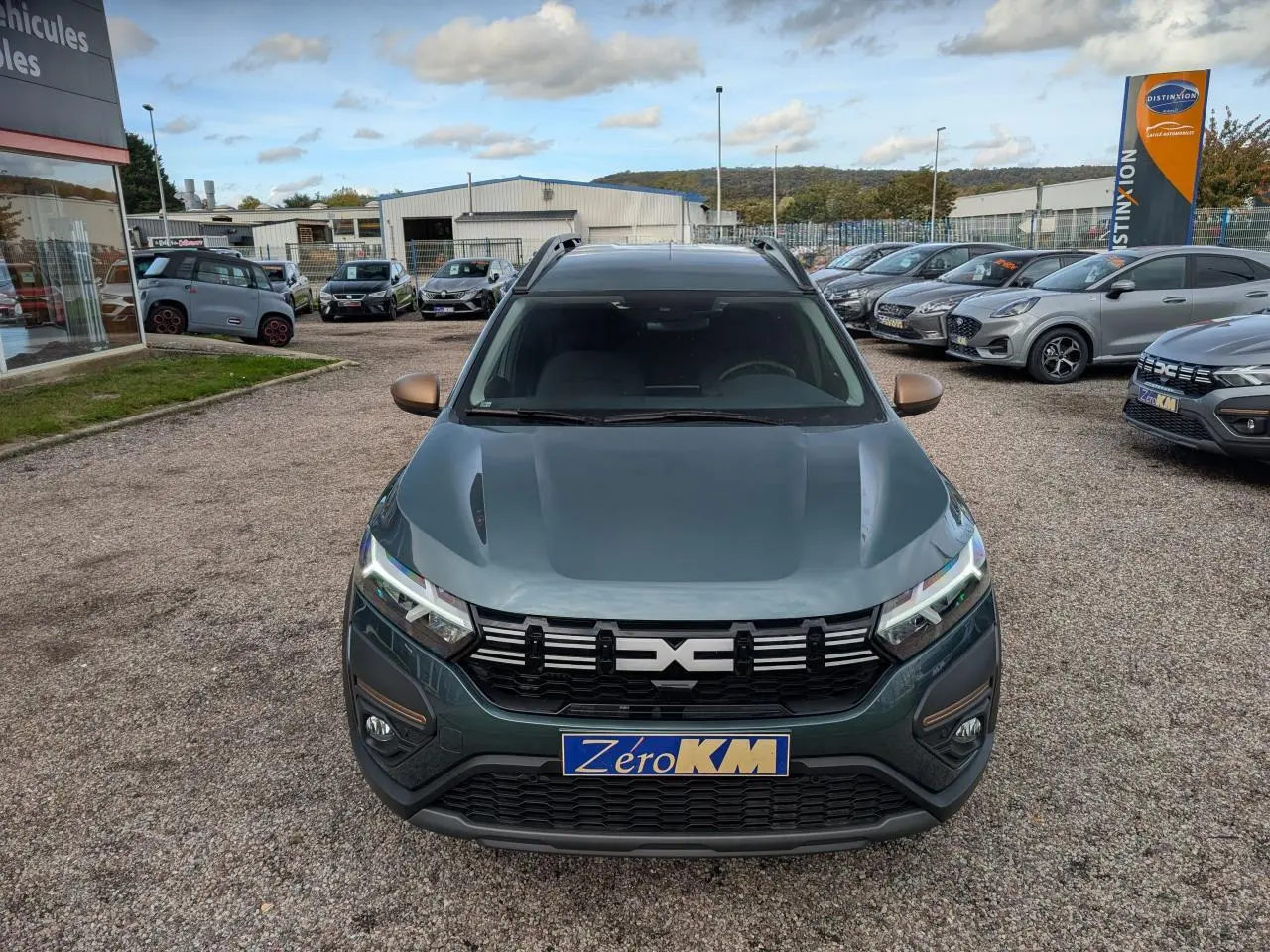Vue avant d'un Dacia Jogger vert métallisé avec calandre noire et rétroviseurs couleur bronze.