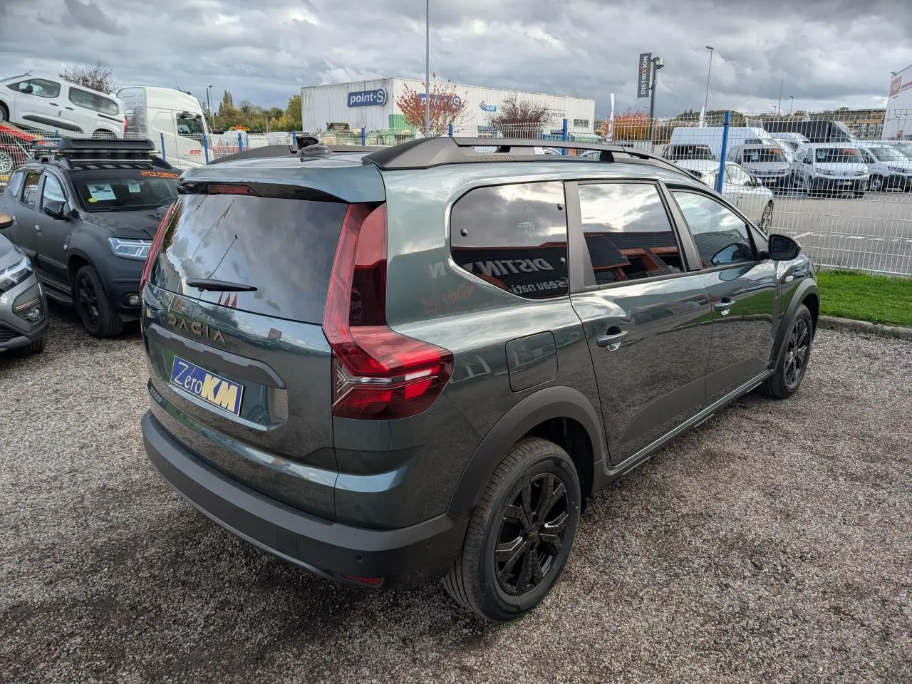 Vue 3/4 arrière droite du Dacia Jogger 2025 vert métallisé avec vitres teintées et jantes noires.
