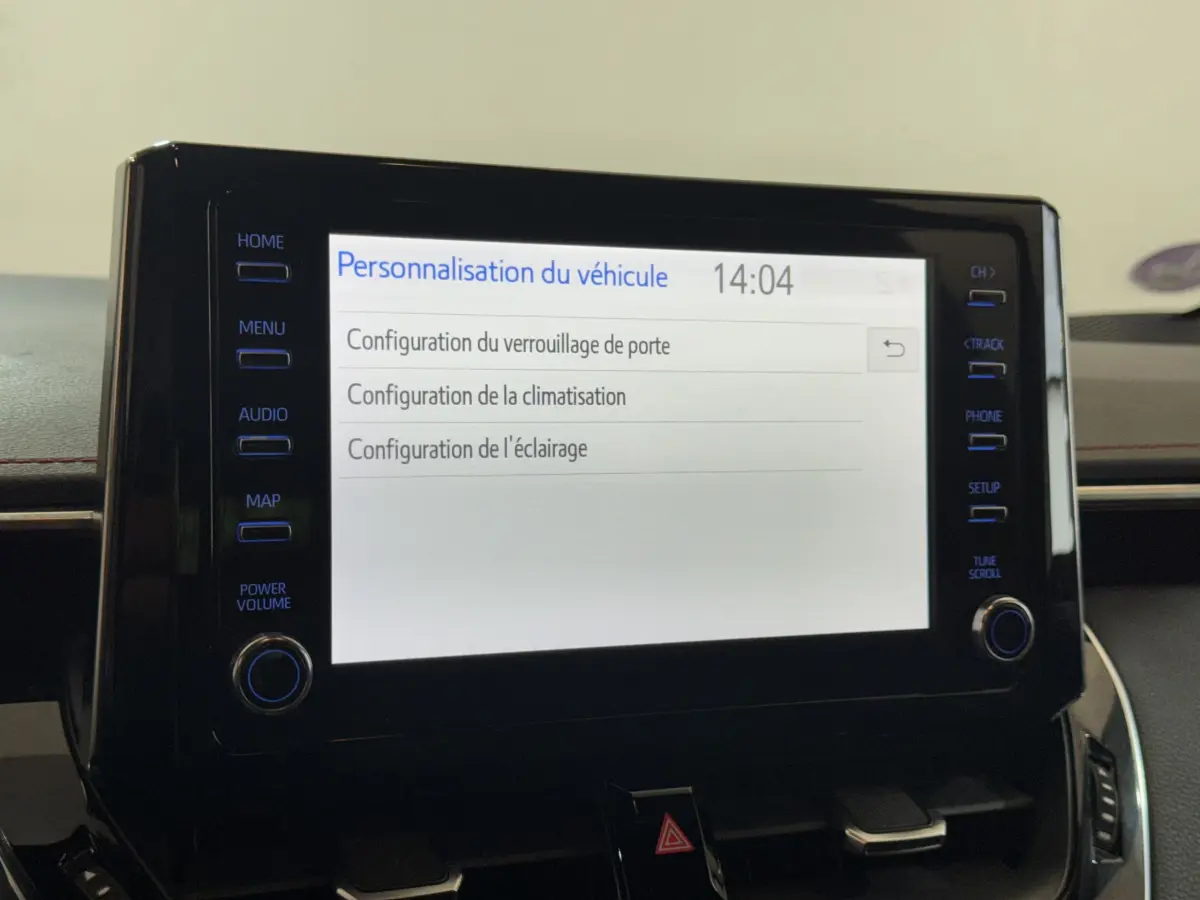 Écran tactile central affichant les options de personnalisation du véhicule dans une Toyota Corolla hybride gris clair.