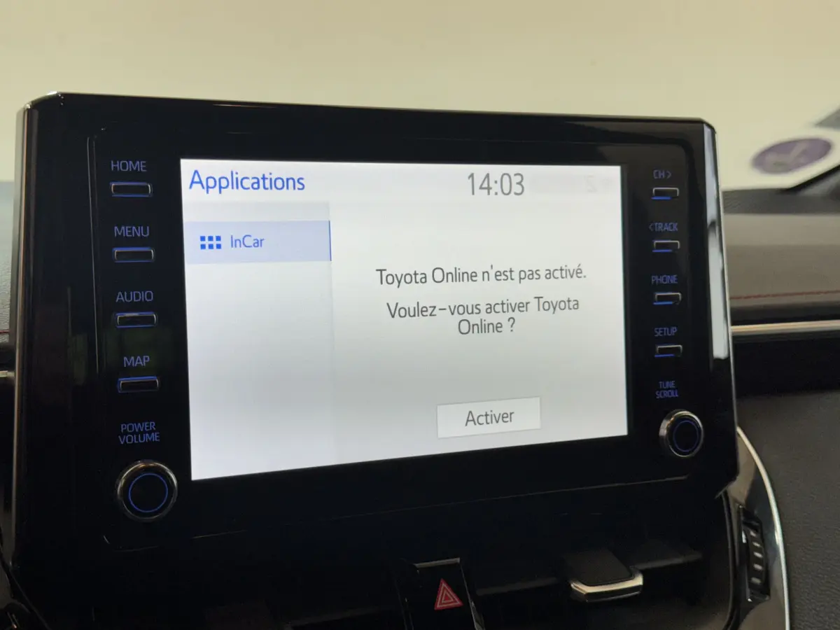 Écran tactile central allumé du tableau de bord de la Toyota Corolla Hybride 122h Collection 2021, intérieur noir.
