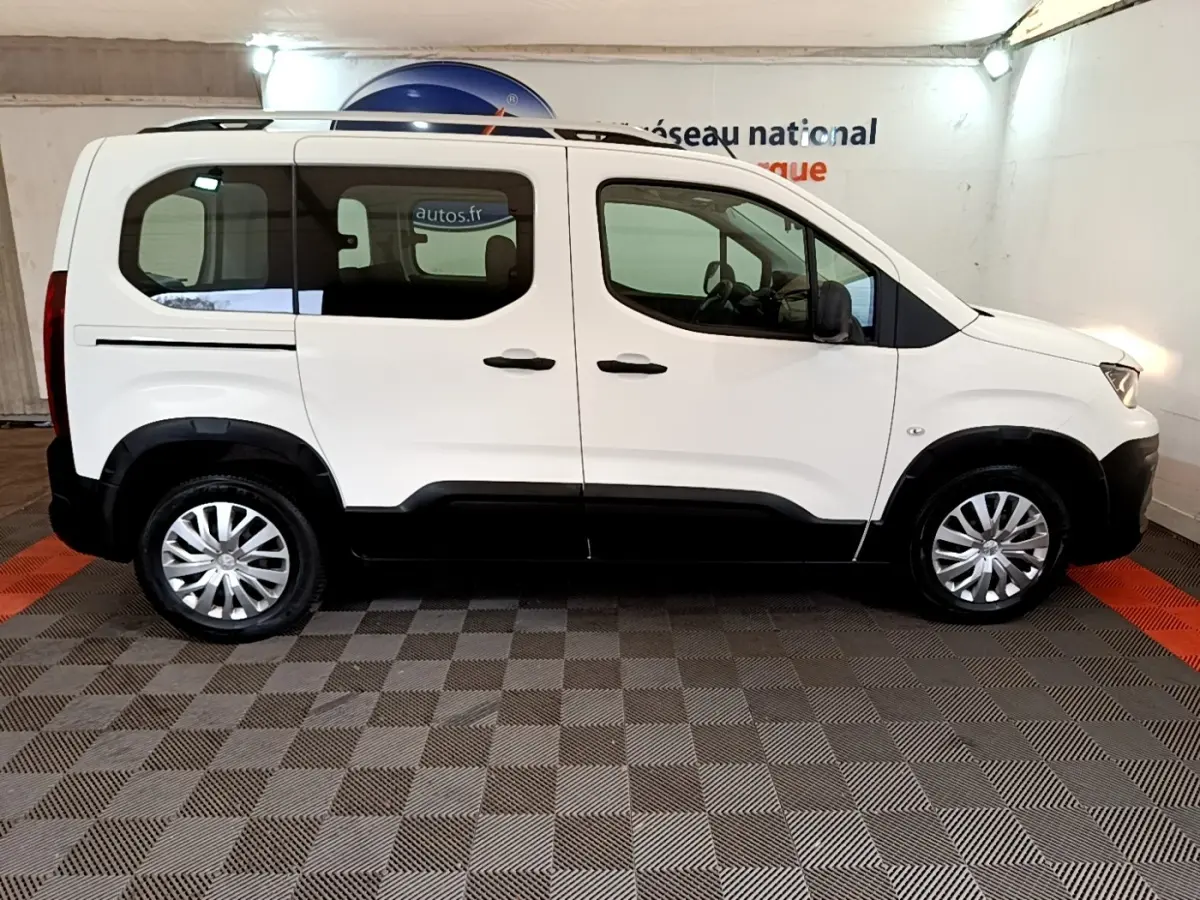 Peugeot Rifter blanc vue de profil côté gauche, avec rails de toit chromés et jantes acier à enjoliveurs.