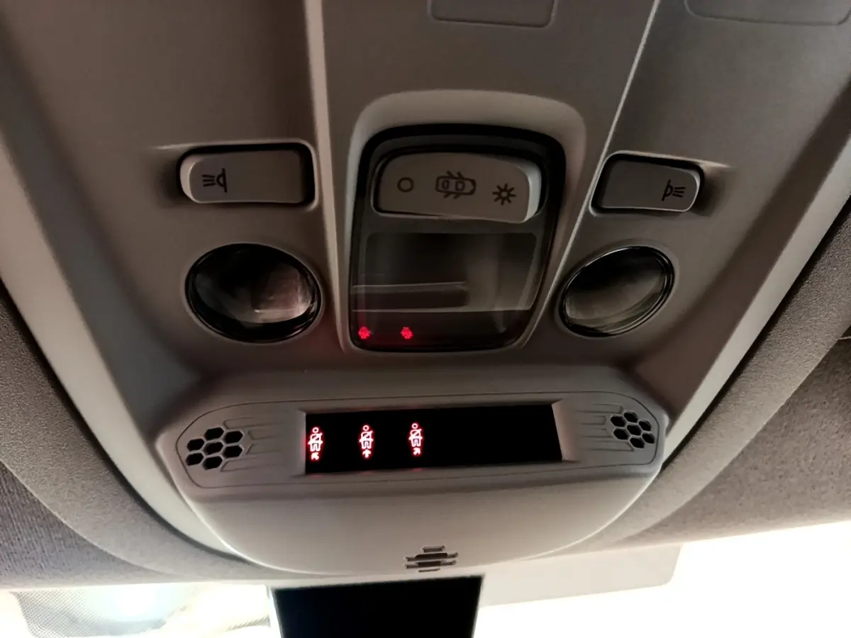 Vue en contre-plongée du plafonnier gris avec commandes d’éclairage et indicateurs de ceinture du Peugeot Rifter blanc 2019.