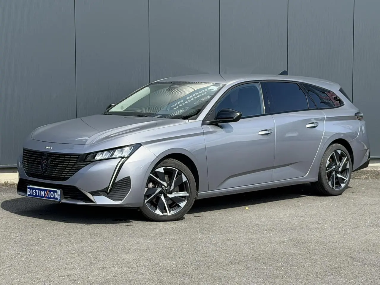 Peugeot 308 SW gris Artense vue 3/4 avant droit, jantes alliage 17'' et vitres latérales surteintées.