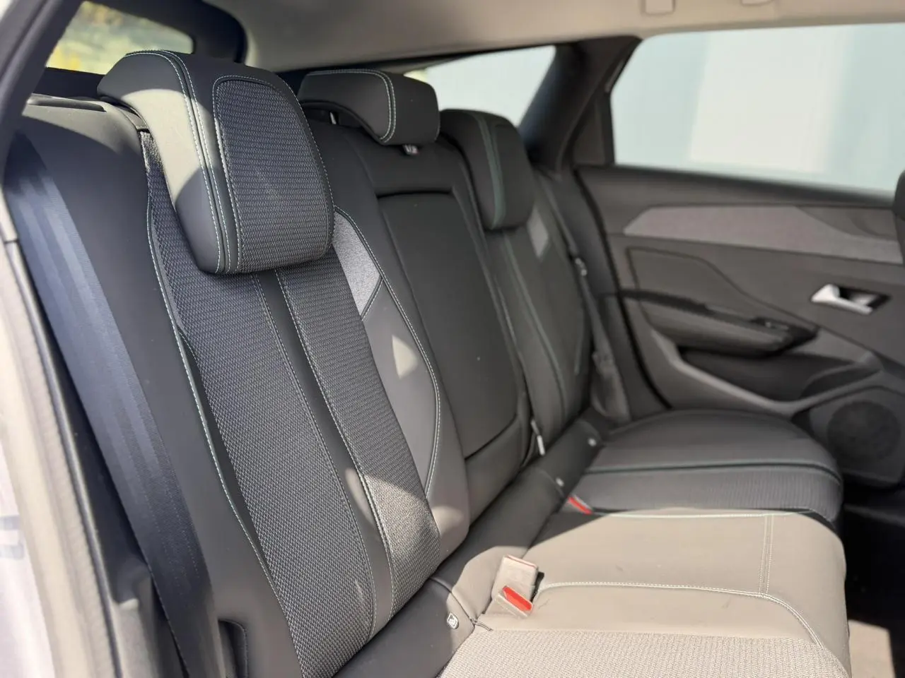 Vue intérieure des sièges arrière en sellerie tri matières noire et tissu avec surpiqûres bleues du Peugeot 308 SW 2025.