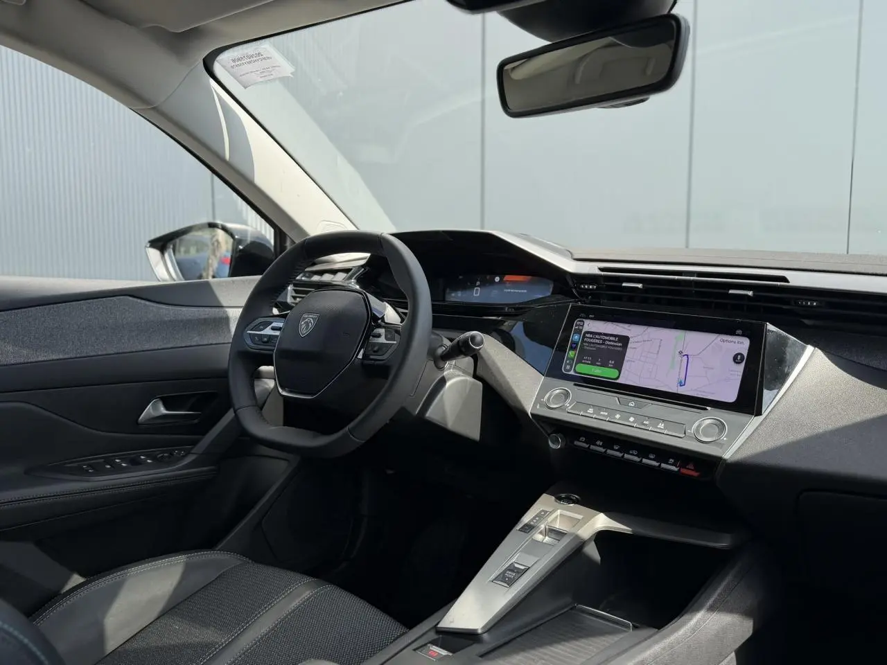 Vue intérieure côté conducteur du Peugeot 308 SW 2025 gris Artense, avec tableau de bord digital et écran tactile central.
