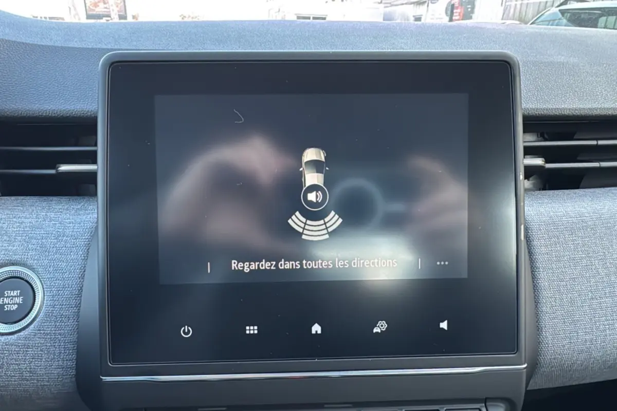 Écran tactile central de la Renault Clio 2025 gris schiste, avec bouton start/stop visible à gauche.