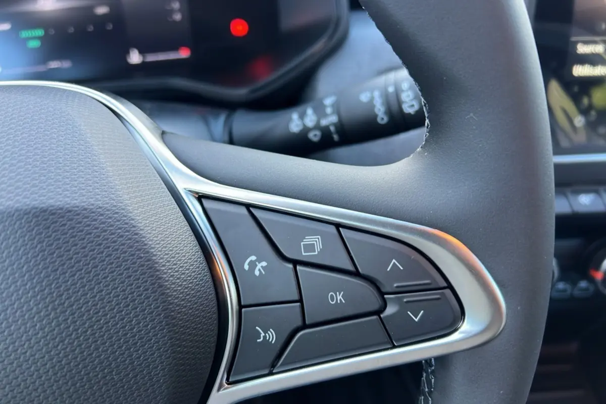 Gros plan sur les commandes multifonctions à droite du volant de la Renault Clio 2025 gris schiste, finition Evolution PK Look.