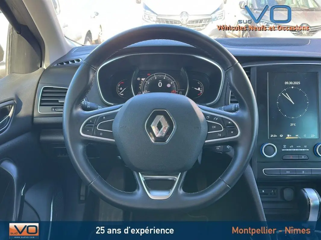 Vue frontale du volant cuir et du tableau de bord numérique de la Renault Mégane IV beige avec écran tactile et commandes intégrées.