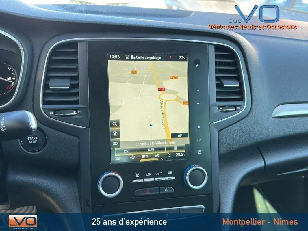 Tableau de bord de Renault Mégane IV beige, vue centrée sur l'écran tactile avec navigation affichée.