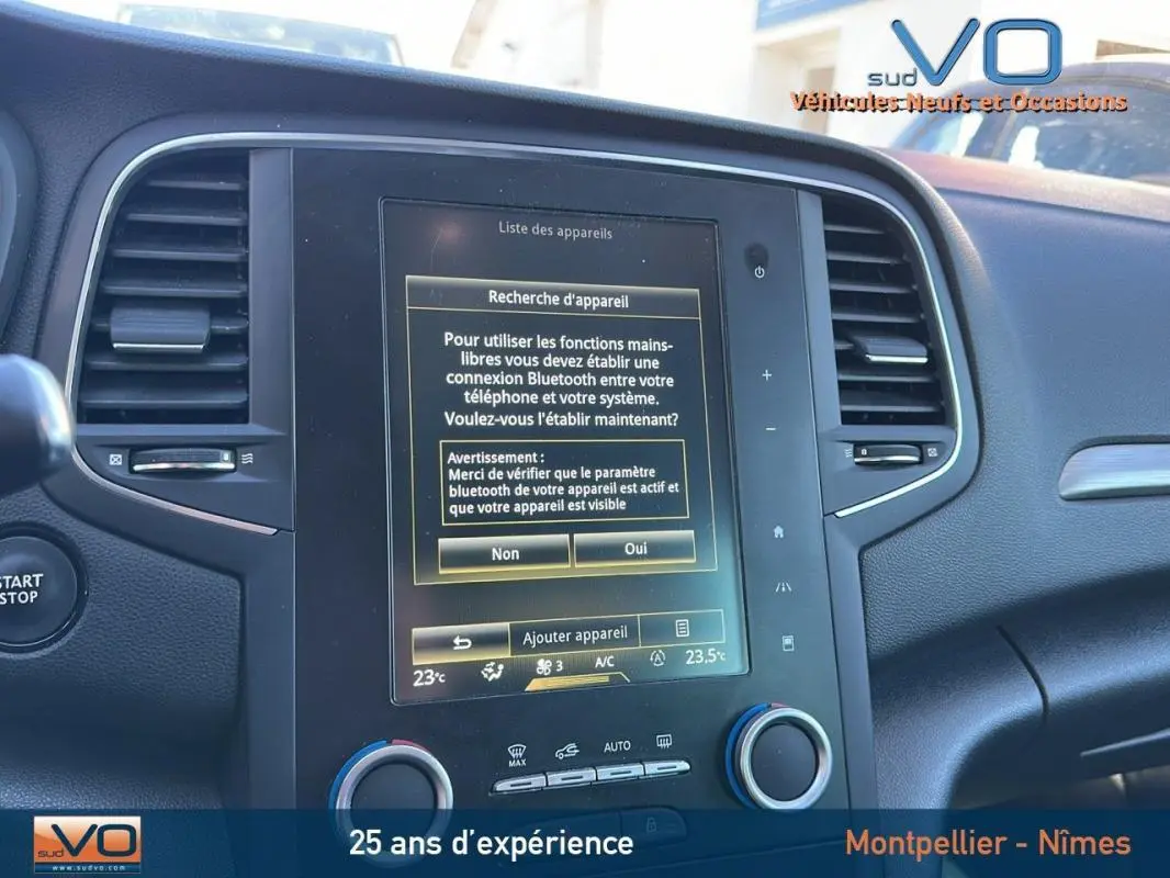 Tableau de bord de Renault Mégane IV beige, vue rapprochée sur l'écran tactile central avec menu Bluetooth affiché.