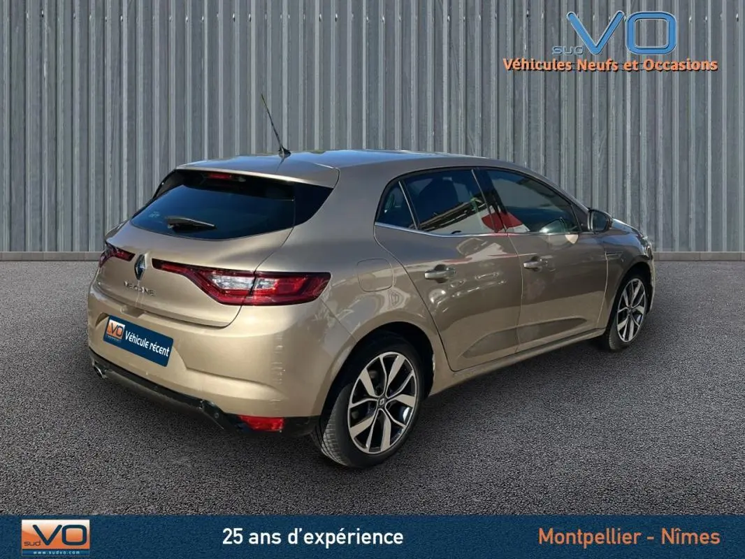 Vue 3/4 arrière droite d'une Renault Mégane IV beige, berline compacte avec feux arrière LED et jantes alliage.