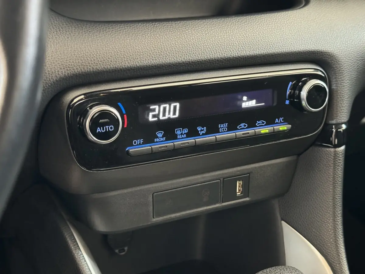 Gros plan sur la commande de climatisation digitale noire affichant 20°C dans l'habitacle de la Toyota Yaris blanche hybride 2022.