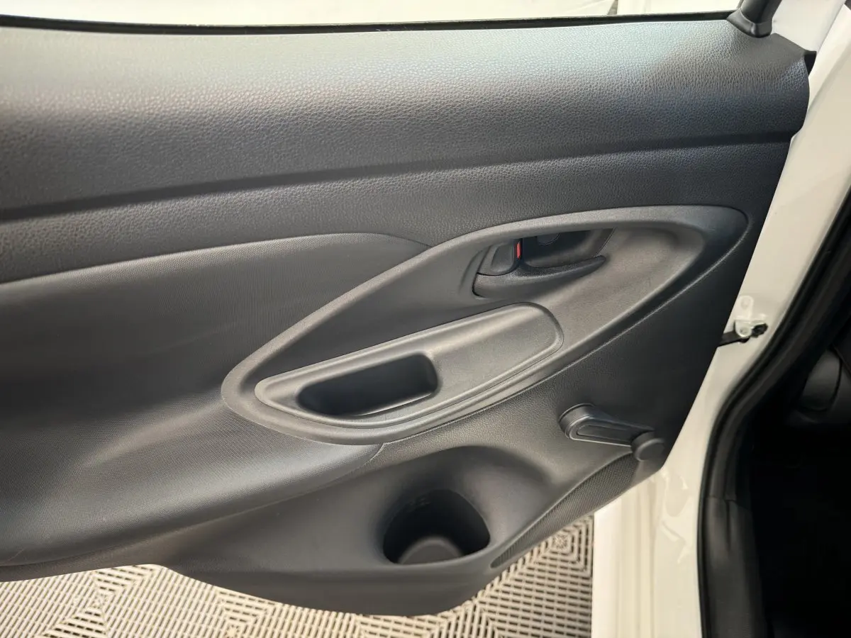 Gros plan sur la porte avant droite noire de la Toyota Yaris blanche hybride 2022, avec poignée et manivelle de vitre.