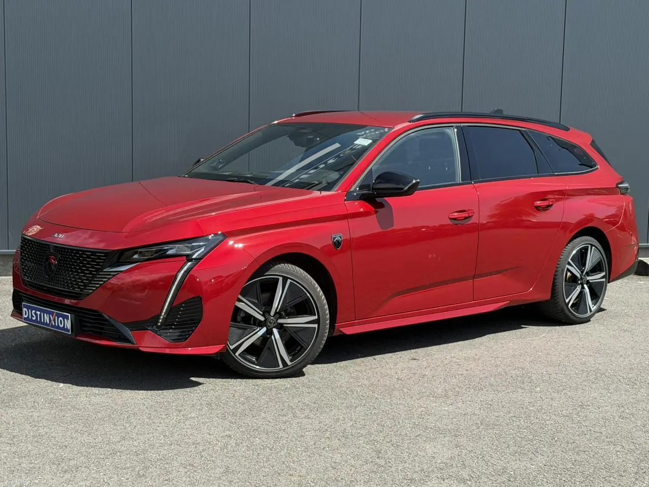 Peugeot 308 SW Rouge Elixir vue 3/4 avant droit avec jantes alliage 18'' et toit noir contrasté.