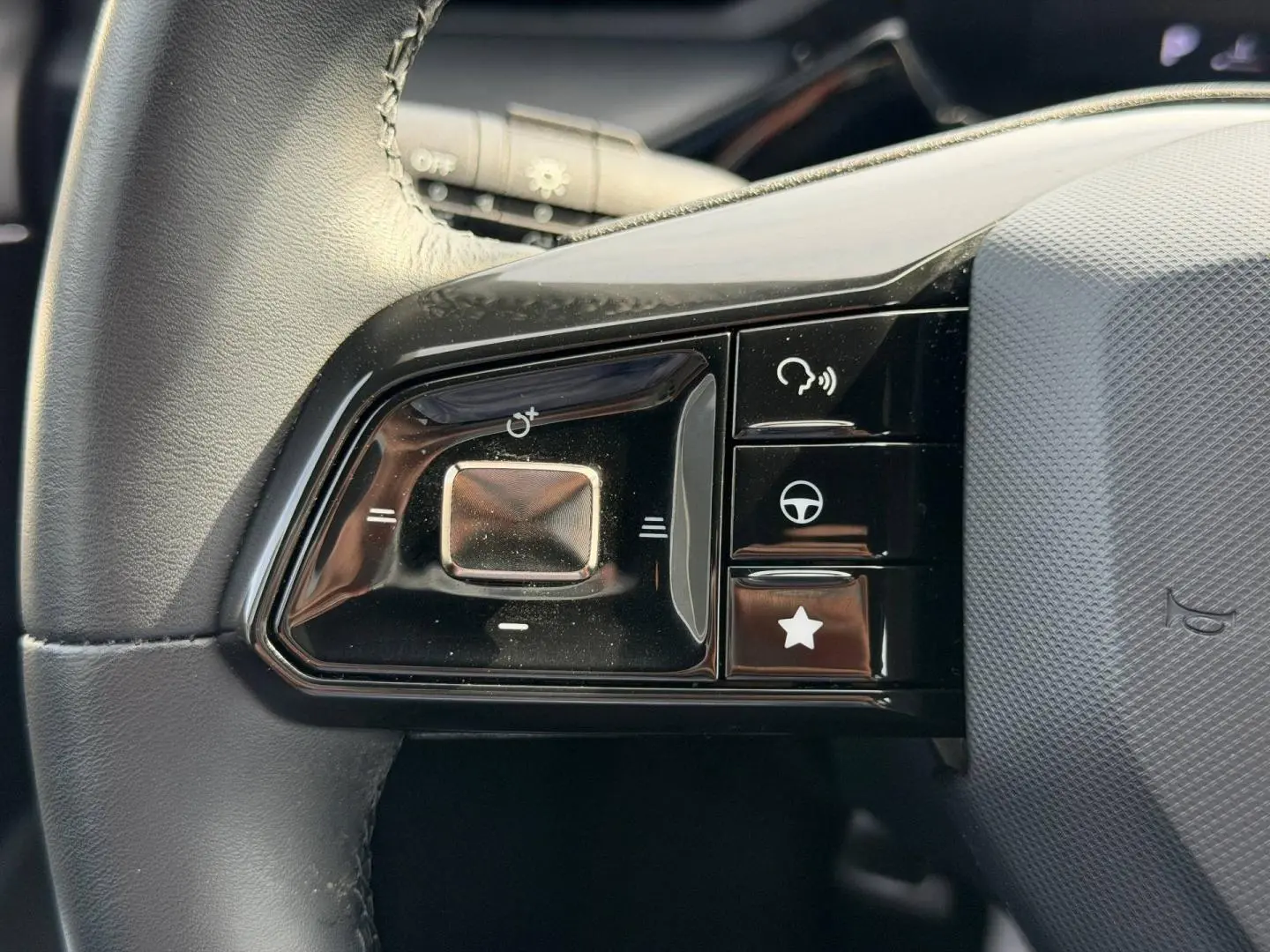 Gros plan sur les commandes noires à gauche du volant cuir noir du MG3 1.5 Hybrid+ Luxury 2025.
