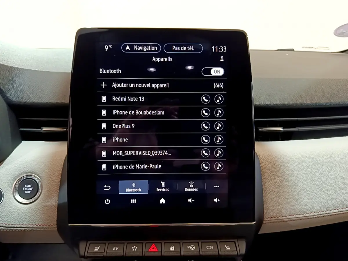 Gros plan sur l'écran tactile central et le tableau de bord beige de la Renault Clio Initiale Paris E-TECH 140 2021.