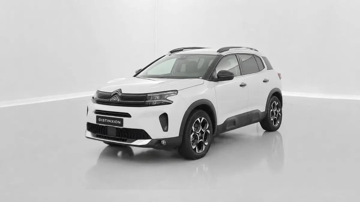 Citroën C5 Aircross hybride blanc en 3/4 avant droit, avec jantes distinctives et protections noires sur les bas de caisse.