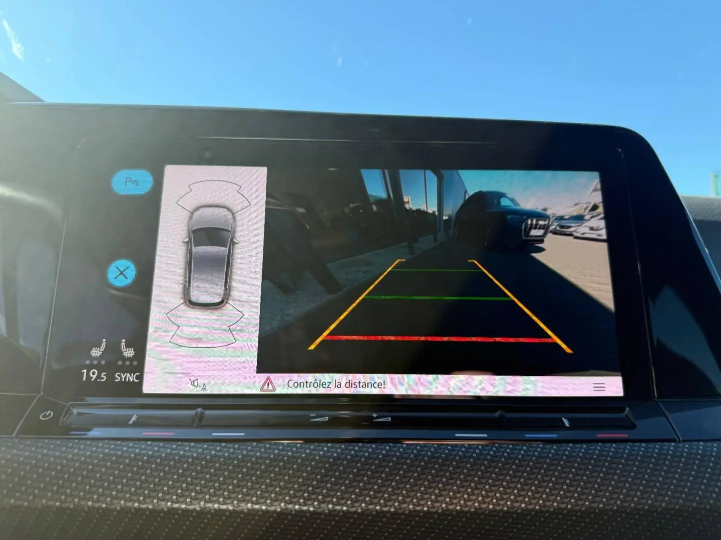 Écran tactile intérieur montrant la caméra de recul d'une Volkswagen Golf noir Grenadilla, vue arrière en stationnement.