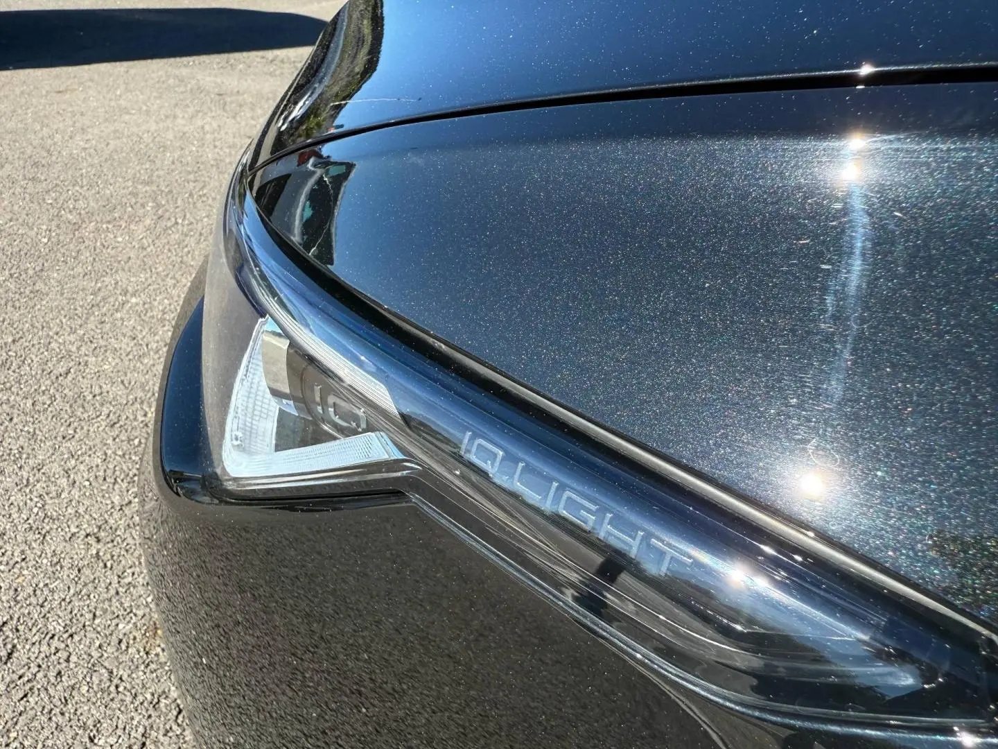Gros plan sur le phare avant droit noir grenadilla métallisé avec inscription IQ.LIGHT sur une Volkswagen Golf 2024.