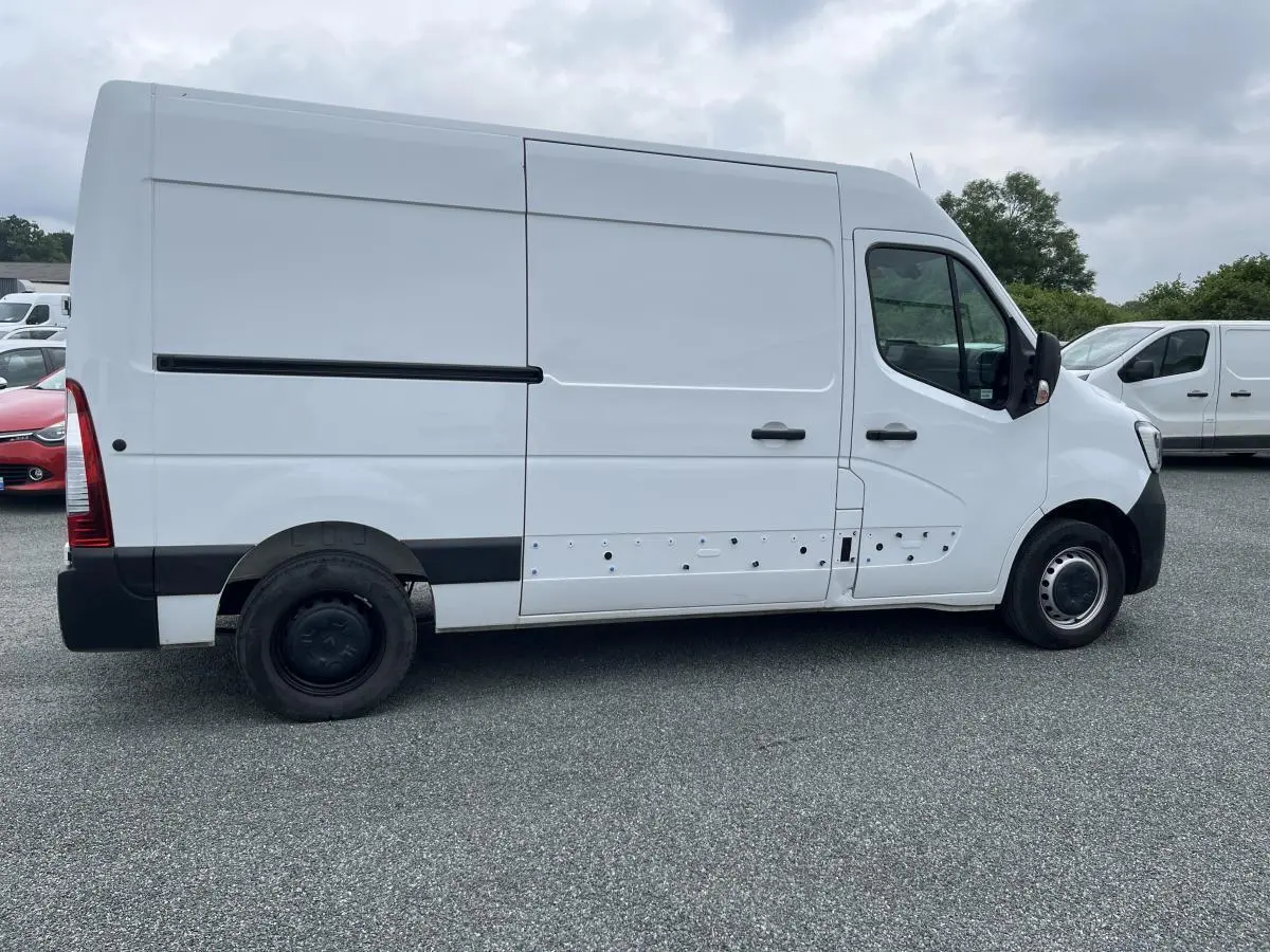 Profil droit d'un Renault Master blanc 2022, fourgon utilitaire avec porte latérale coulissante et jantes tôlées noires.