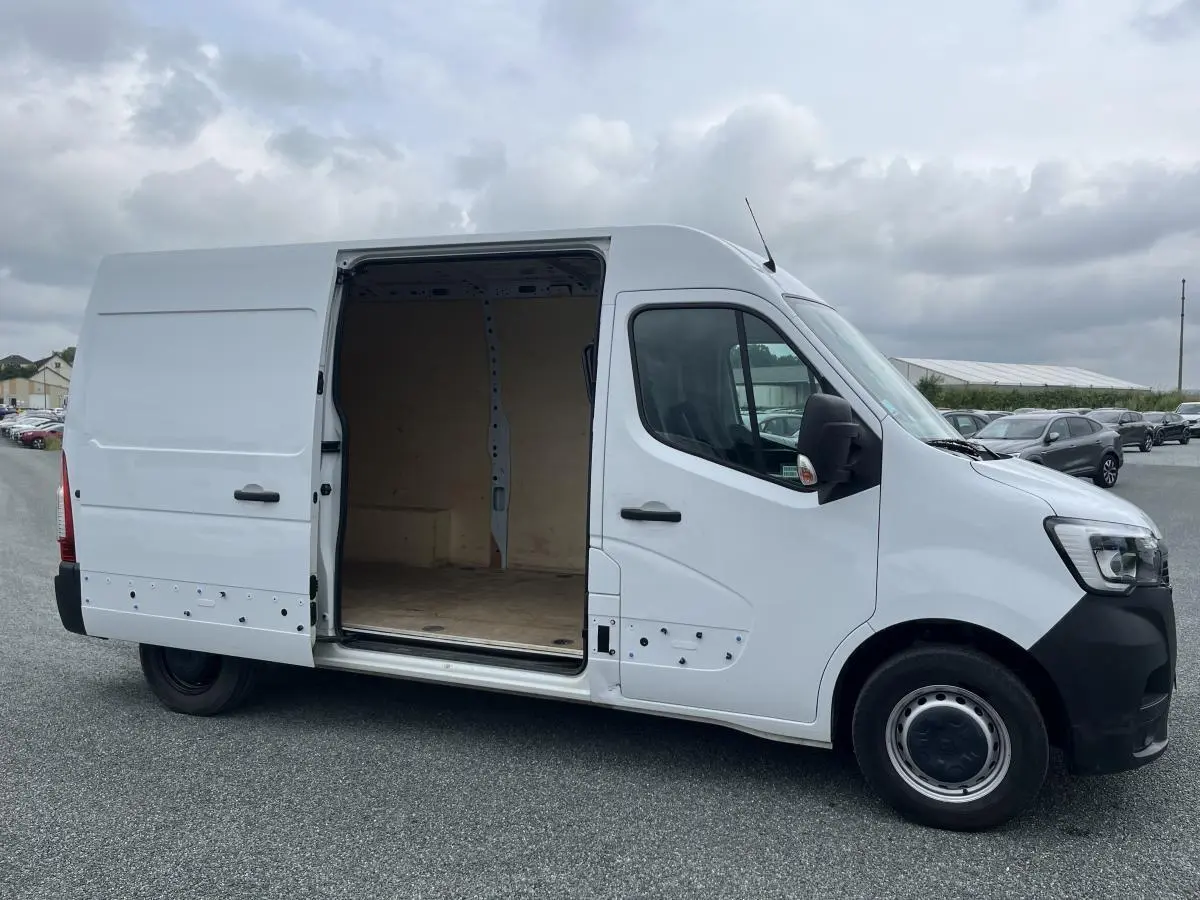 Renault Master blanc vue de profil côté droit avec porte latérale coulissante ouverte montrant l'espace de chargement vide.
