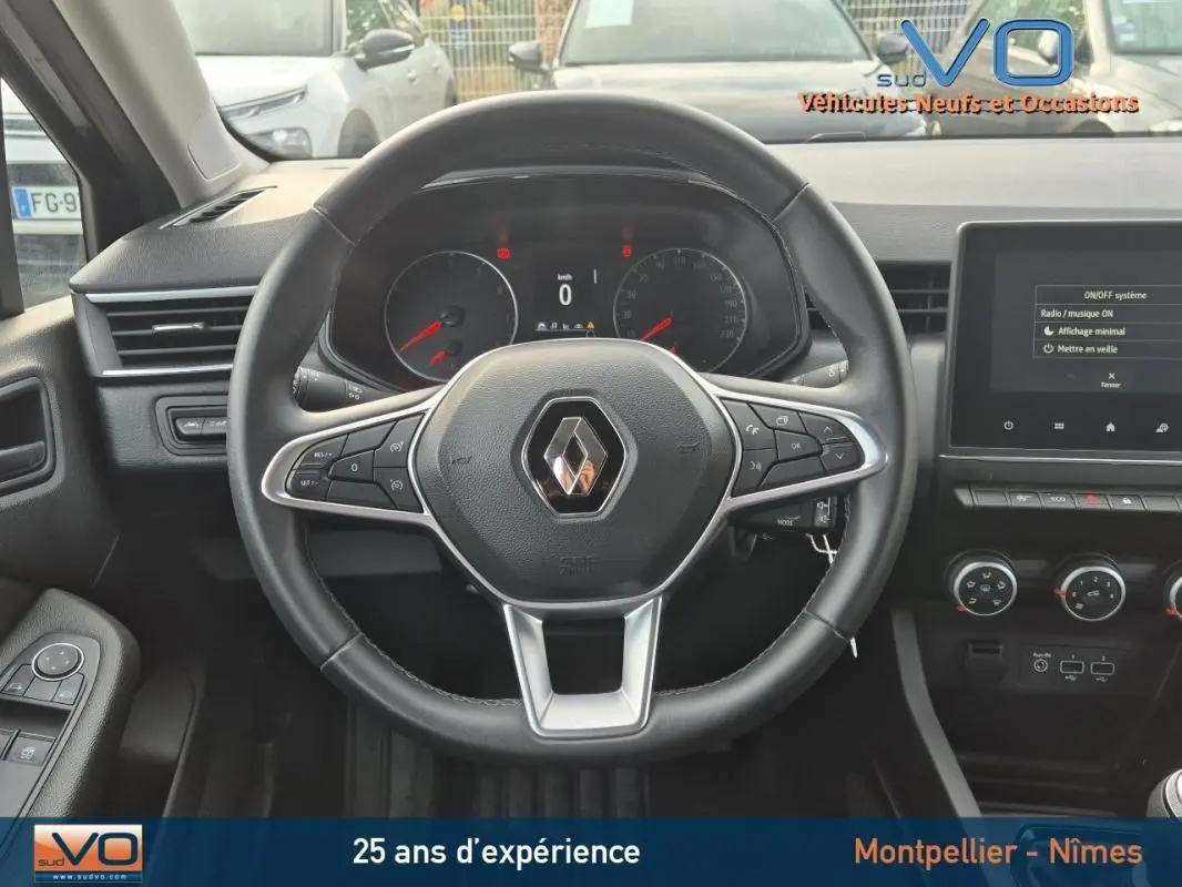 Vue intérieure centrée sur le volant Renault Clio noir 2023 avec commandes multifonctions et tableau de bord digital.