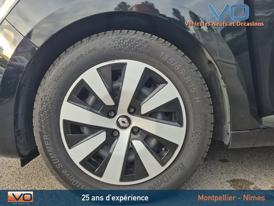 Gros plan sur la roue avant droite de la Renault Clio noire 2023 avec jante alliage distinctive et pneu été.