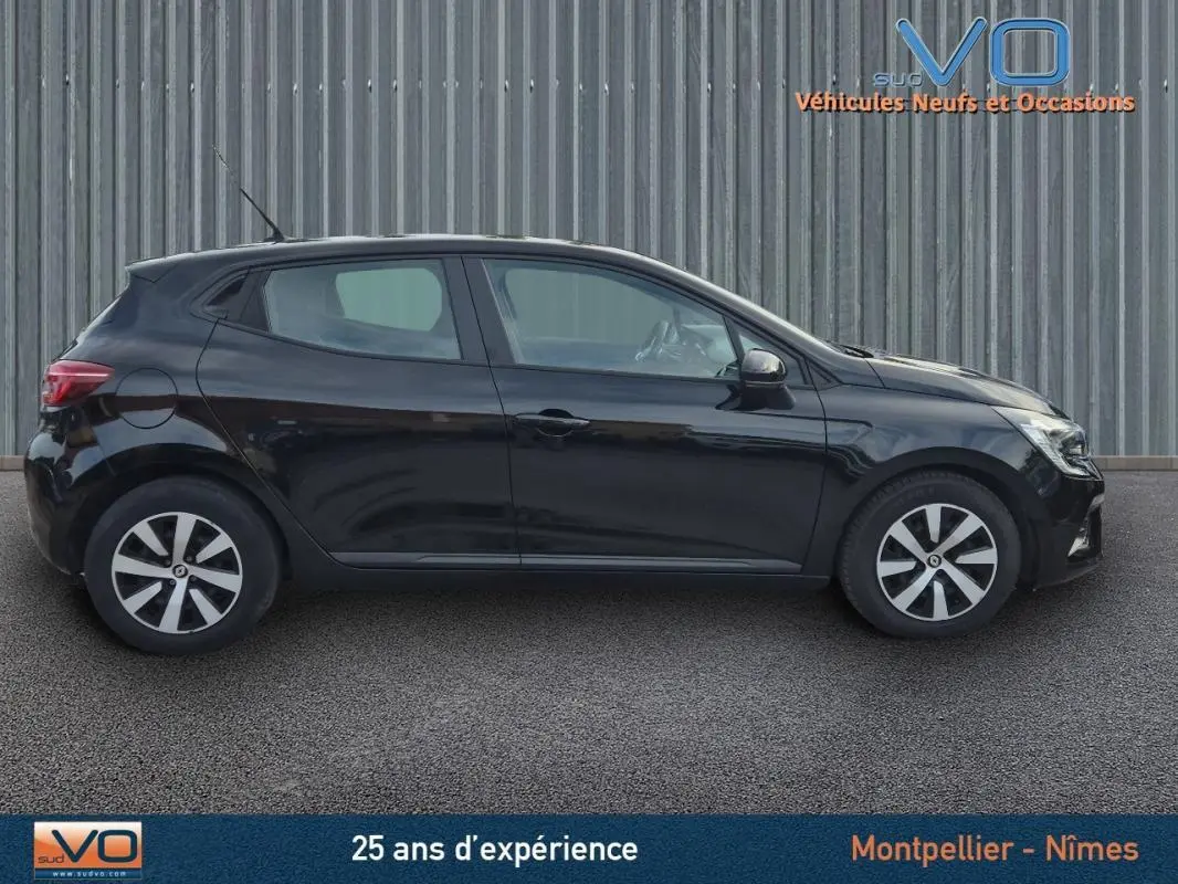 Profil latéral gauche d'une Renault Clio V TCe 90 Equilibre noire de 2023, avec jantes stylisées et antenne de toit visible.