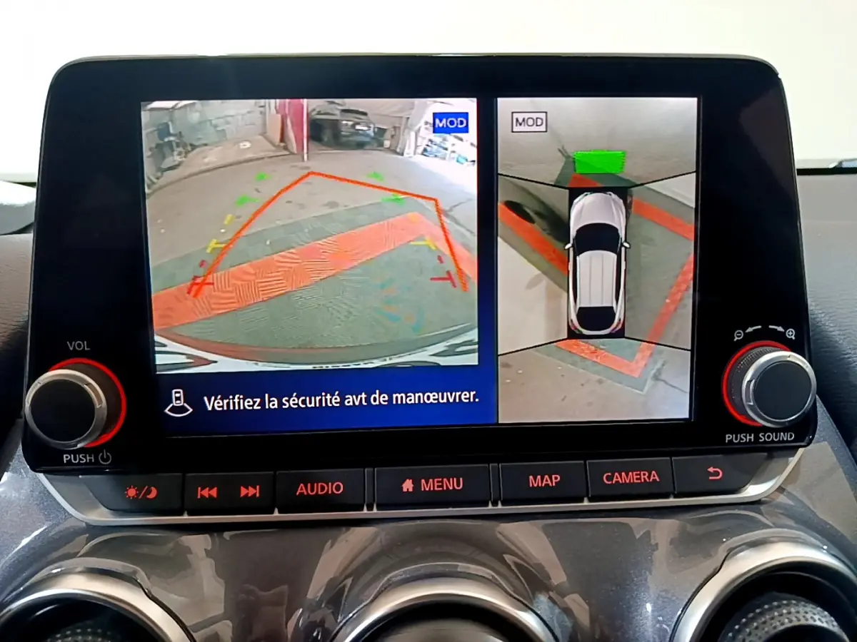 Écran tactile central du Nissan Juke Hybrid 2023 affichant la caméra de recul et la vue à 360° en intérieur gris foncé.
