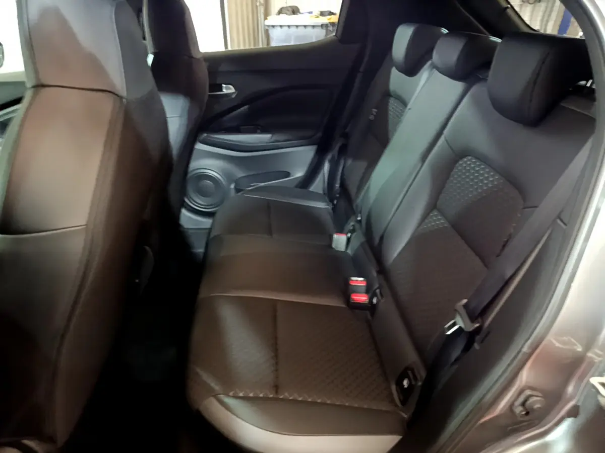 Vue côté droit de la banquette arrière en cuir noir du Nissan Juke Hybrid 143 Business+ 2023, avec appuie-têtes intégrés.