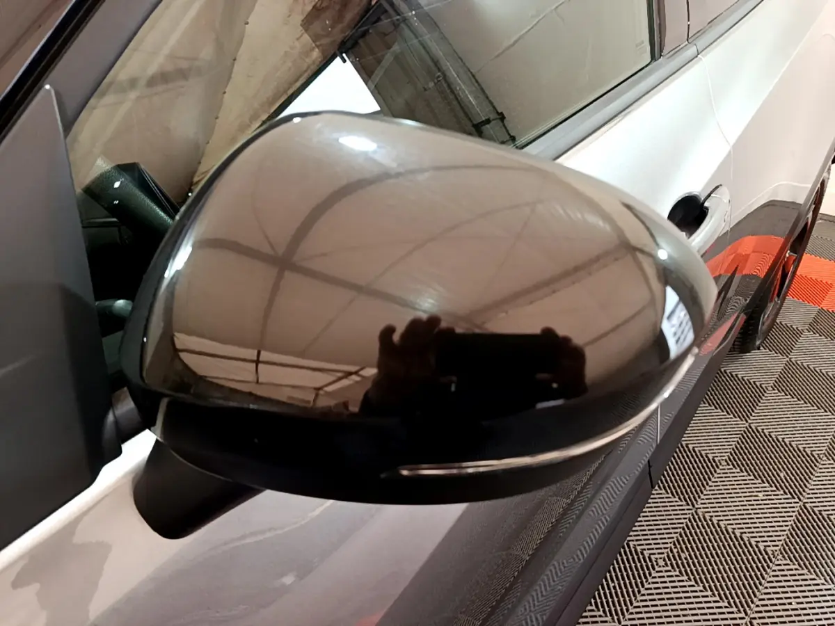 Rétroviseur droit noir brillant du Nissan Juke Hybrid gris foncé, vue rapprochée sur la portière côté droit.