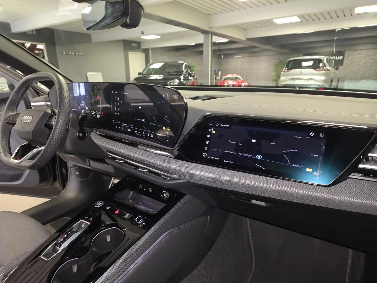 Vue intérieure côté conducteur de l'Audi A5 Avant 2025 noire, avec tableau de bord numérique et écran tactile central.
