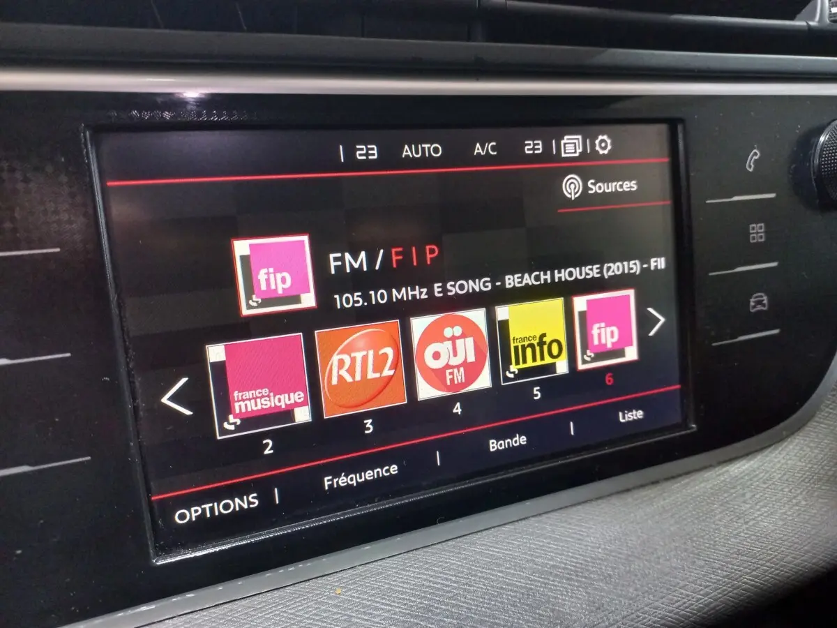 Écran tactile central affichant la radio FM dans l'habitacle du Citroën Grand C4 Spacetourer noir, vue rapprochée.