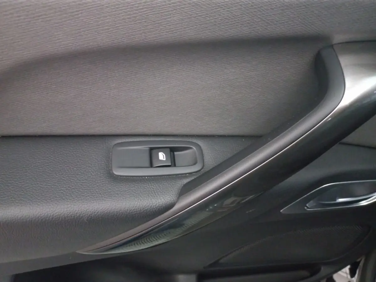 Gros plan sur la commande de lève-vitre côté porte intérieure noire du Citroën Grand C4 Spacetourer 2018.