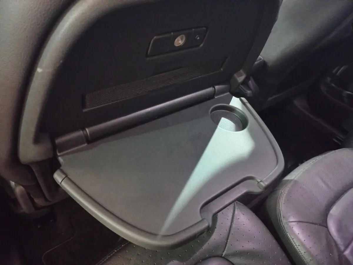 Gros plan sur tablette rabattable avec porte-gobelet côté passager arrière du Citroën Grand C4 Spacetourer noir.