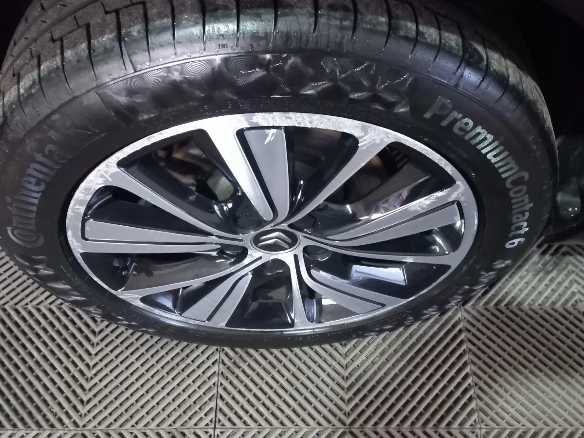 Gros plan sur la jante alliage noire et argentée avec logo Citroën au centre, pneu Continental PremiumContact 6 visible.