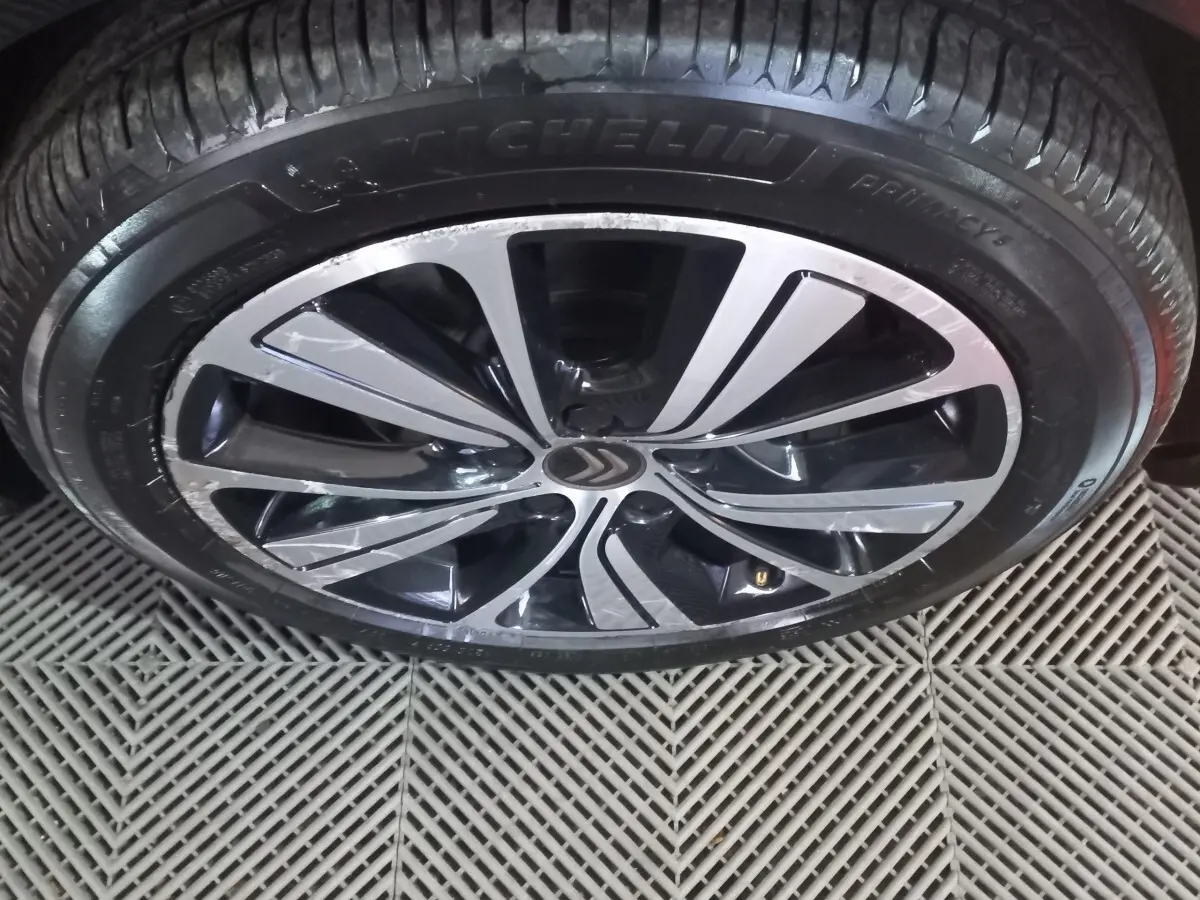 Gros plan sur la jante alliage noire et argentée d’un Citroën Grand C4 Spacetourer noir, pneu Michelin visible.