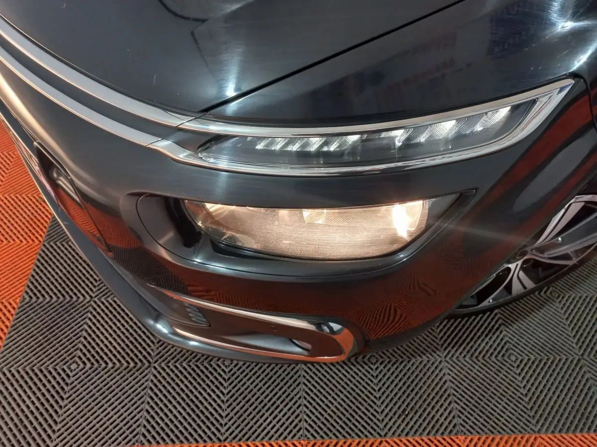 Gros plan sur l'avant droit noir du Citroën Grand C4 Spacetourer avec phares allumés et jante visible.