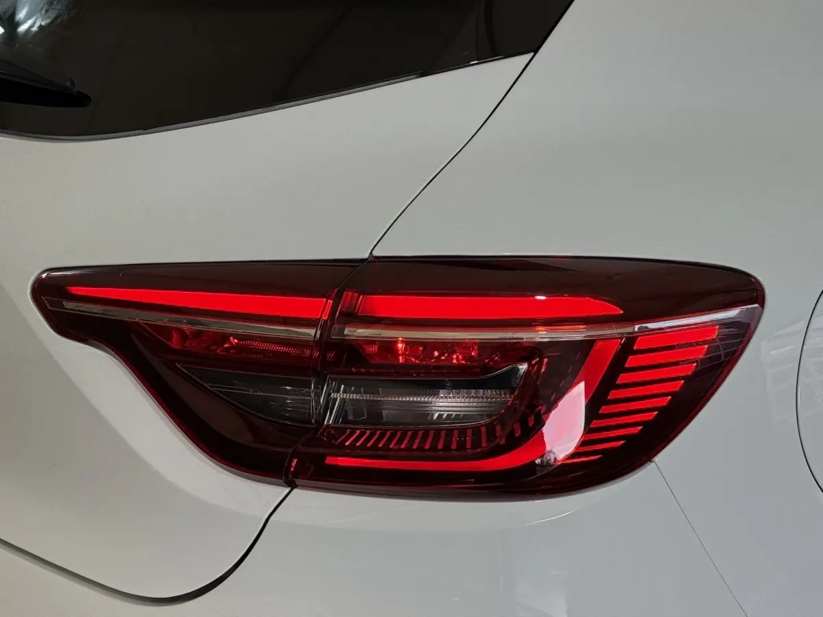 Gros plan sur le feu arrière droit rouge et blanc d'une Renault Clio Business blanche, vue de profil arrière.