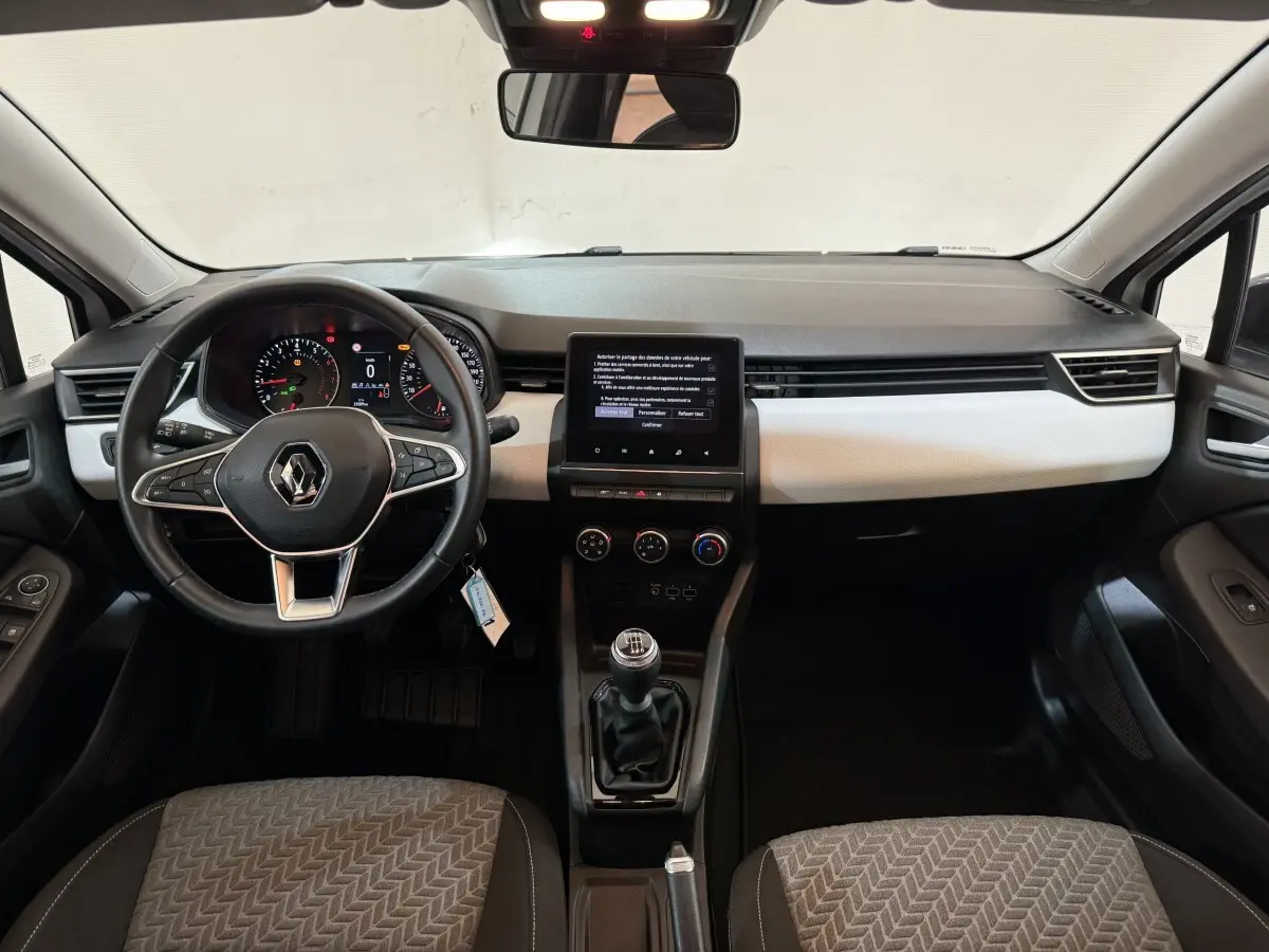 Vue intérieure avant de la Renault Clio Business TCe 100 GPL 2022, tableau de bord noir et blanc avec écran tactile central.