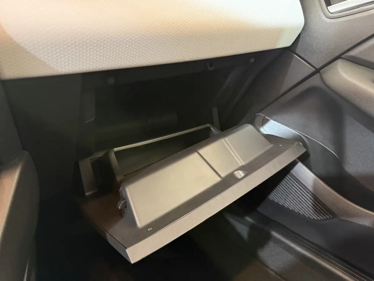 Gant de boîte ouverte côté passager intérieur de la Renault Clio Business blanc, montrant le rangement noir et la planche de bord claire.