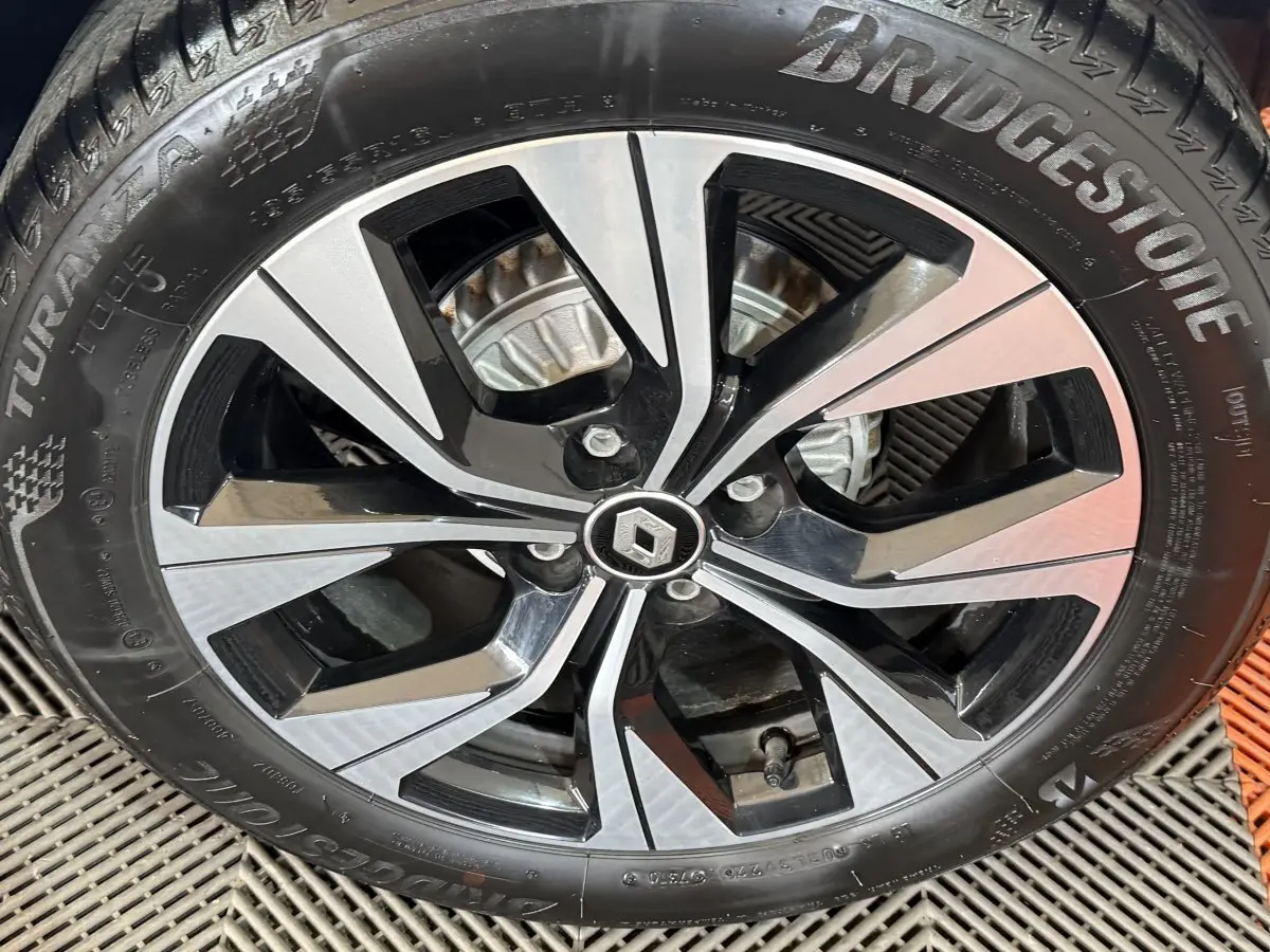 Gros plan sur la jante alliage bicolore noire et argent avec logo Renault au centre sur pneu Bridgestone.