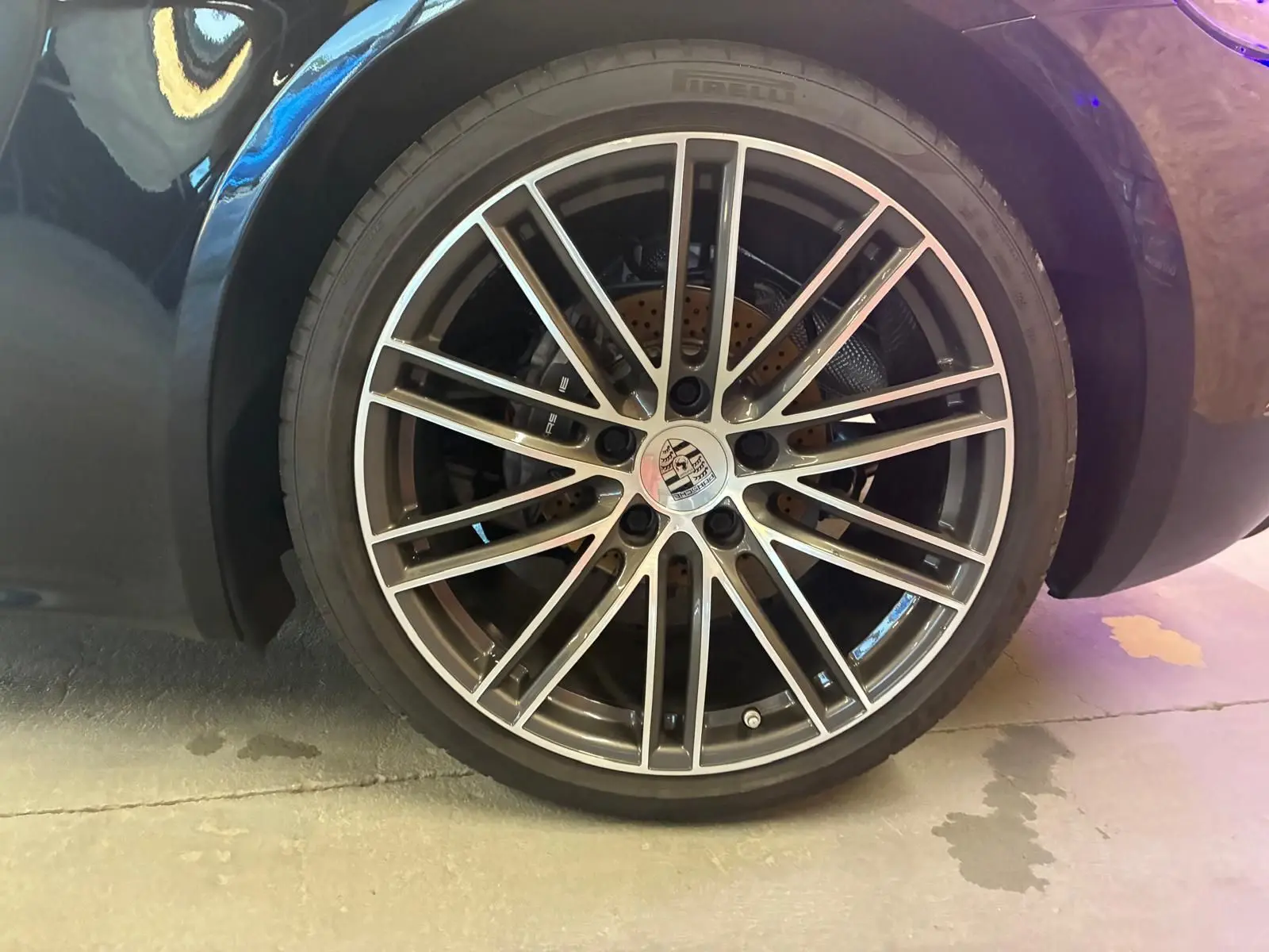Gros plan sur la roue avant gauche noire d'une Porsche 718 Boxster 2.0 300, avec jante alliage multibranches argentée.