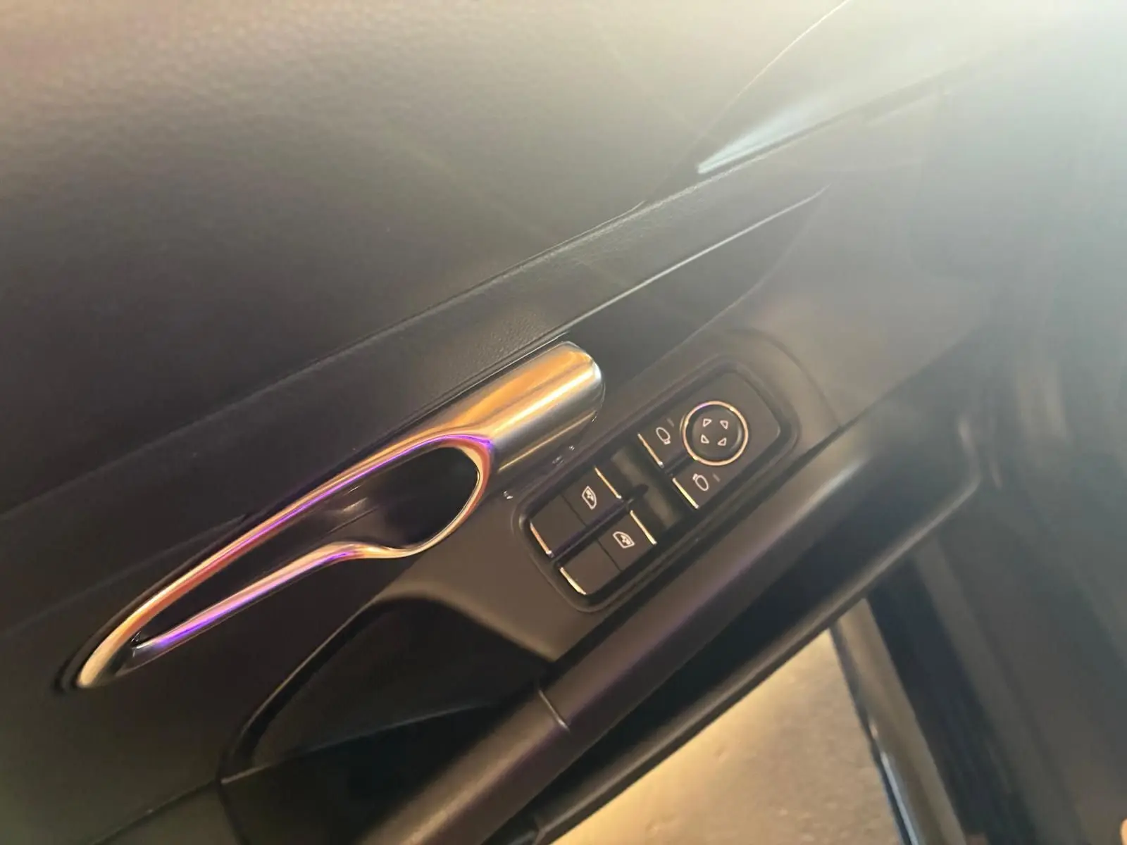 Poignée de porte intérieure côté gauche avec commandes électriques sur Porsche 718 Boxster noir, vue rapprochée.
