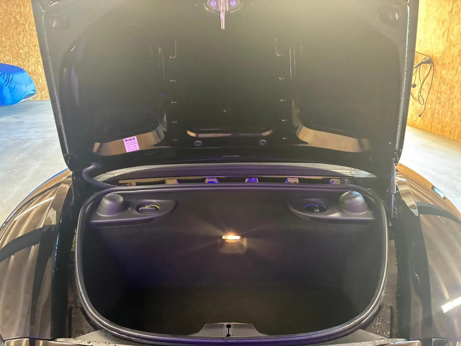 Coffre avant ouvert vu de face sur Porsche 718 Boxster noir 2018, mettant en valeur l’espace de rangement intérieur.