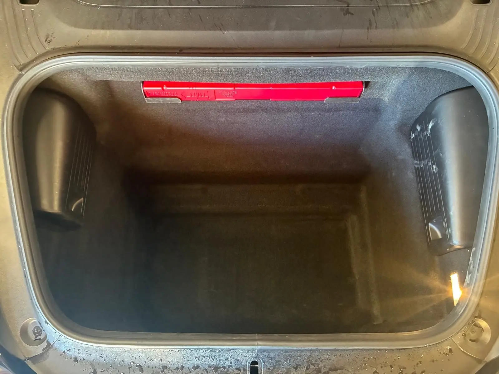 Vue plongeante sur le coffre avant noir vide du Porsche 718 Boxster 2.0 300 de 2018, avec éclairage intérieur.