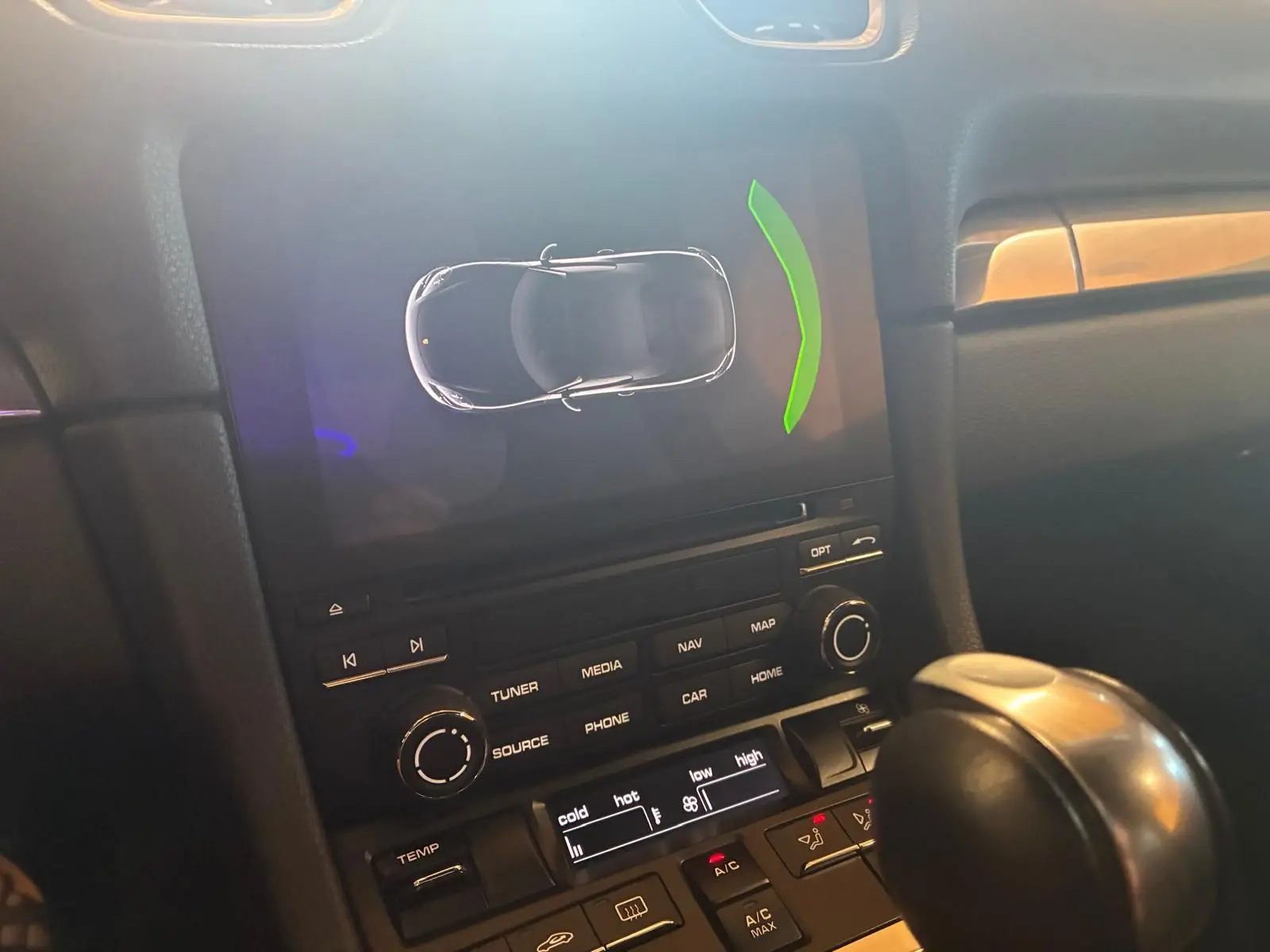 Vue rapprochée de la console centrale de la Porsche 718 Boxster noire, affichant l’écran multimédia et le levier de vitesse automatique.