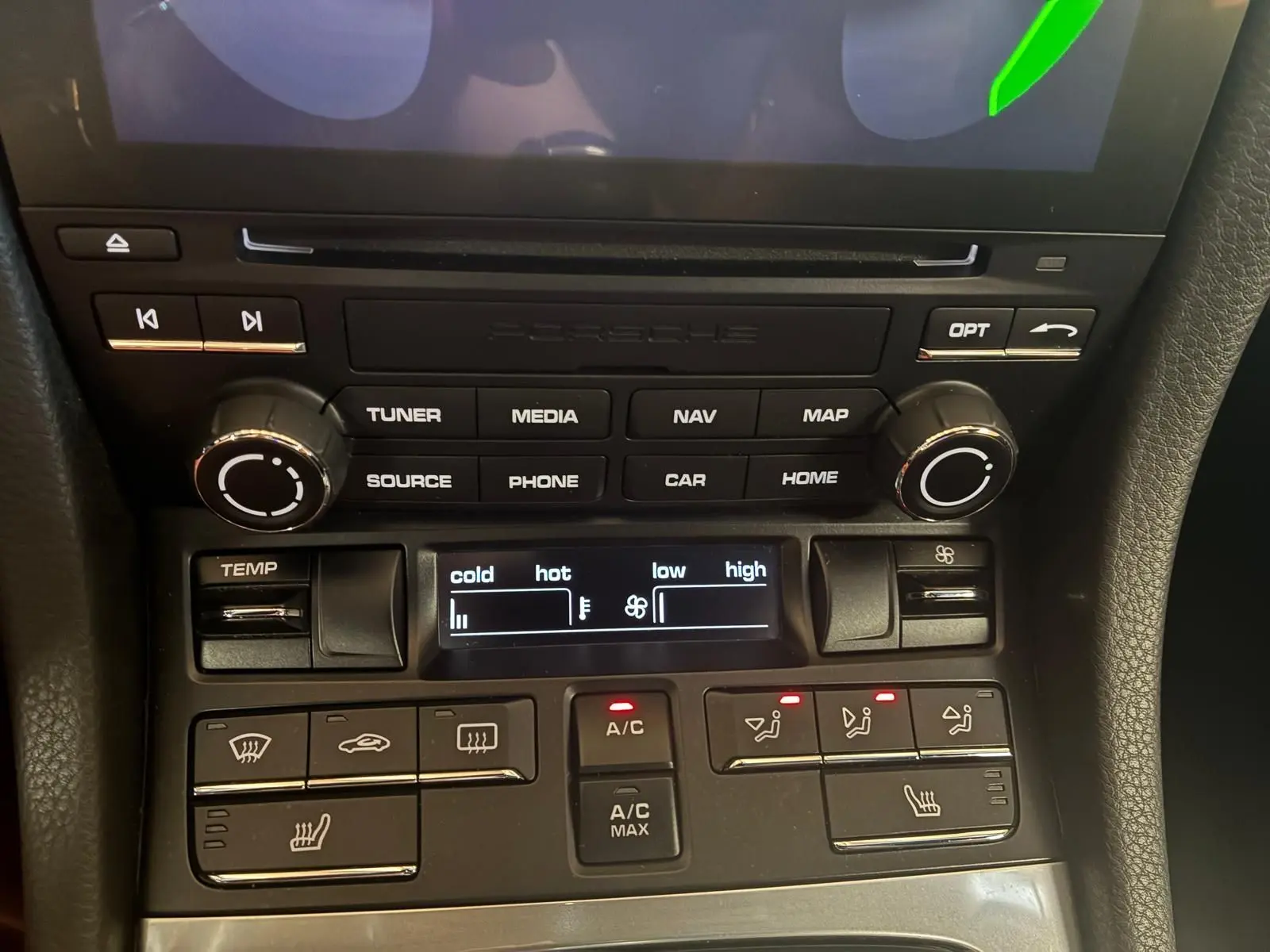 Gros plan sur la console centrale noire de la Porsche 718 Boxster 2.0 300 de 2018, montrant les commandes climatisation et multimédia.