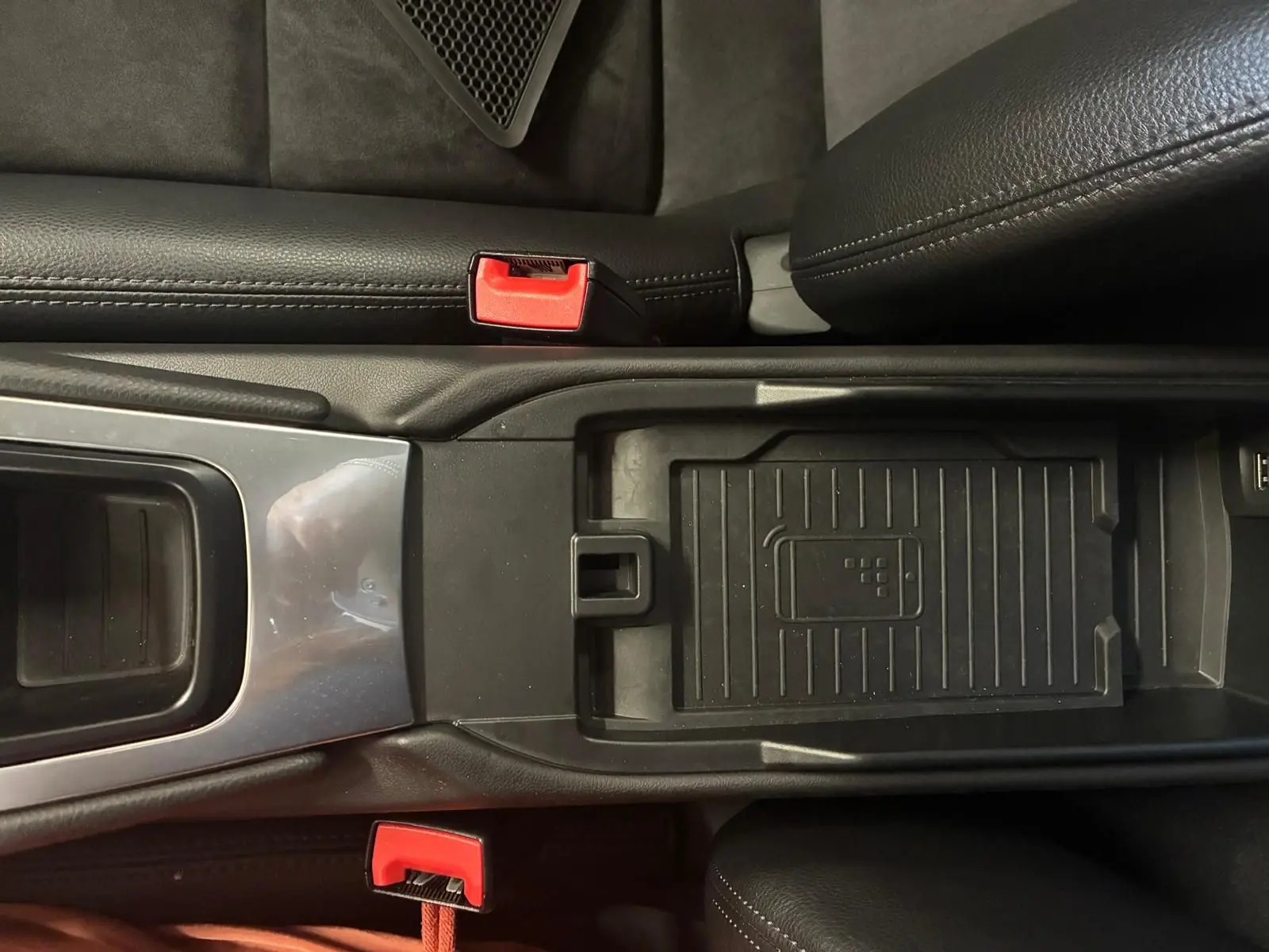 Vue plongeante sur la console centrale noire de la Porsche 718 Boxster 2.0 300, avec détails des ceintures rouges et rangement central.
